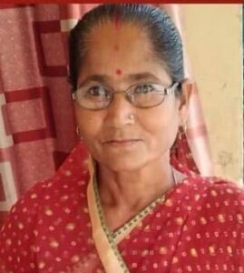 A woman with glasses and dark hair wearing a red sari