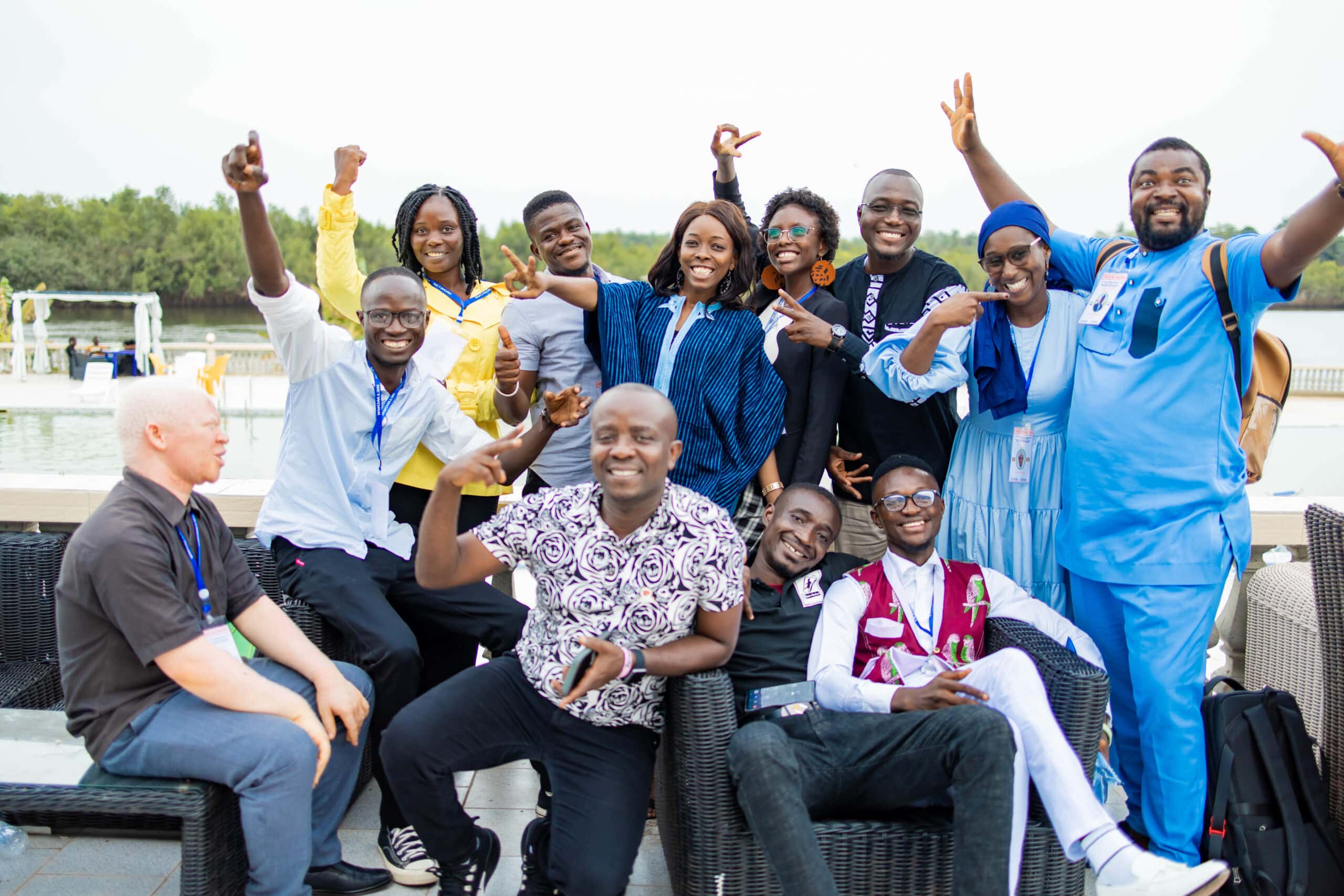 A group of youth activists from the Mano River region raise their hands in celebration.